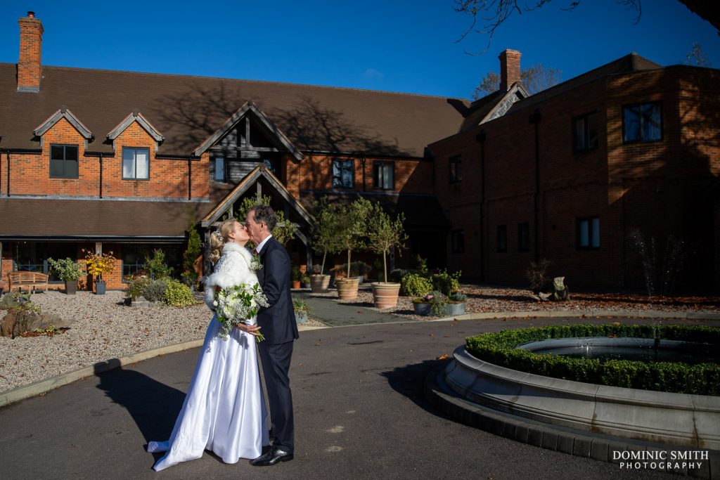 Bride and Groom sharing a kiss outside Cottesmore Golf Club