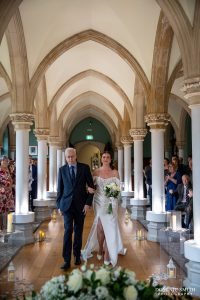 Bride being escorted down the aisle at Wotton House