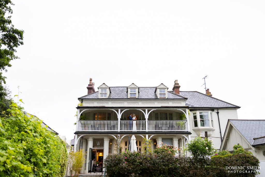 Wide photo of the front of Wingrove House in Sussex with Bride and Groom