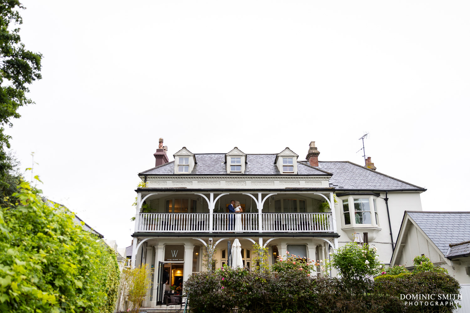 Wide photo of the front of Wingrove House in Sussex with Bride and Groom