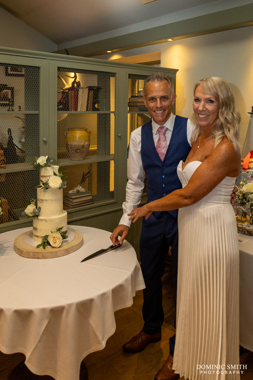 Bride and Groom cut the wedding cake at Wingrove House
