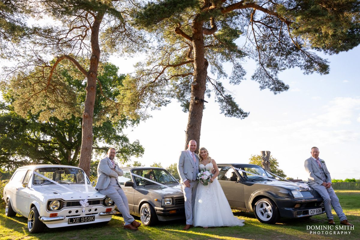 Bride and Groom with the classic cars at Cottesmore