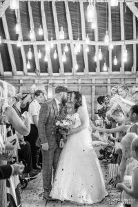Kissing during confetti at Southlands Barn, Sussex