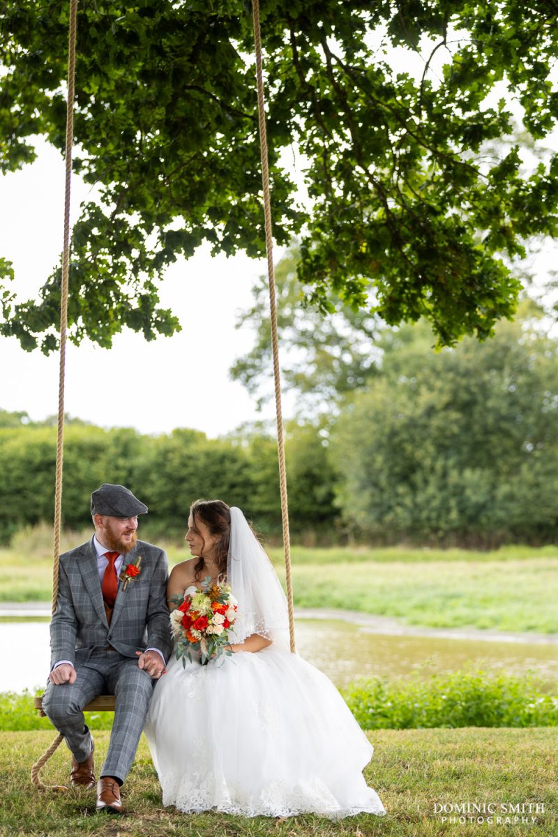 Bride and Groom on the swing at Southlands Barns