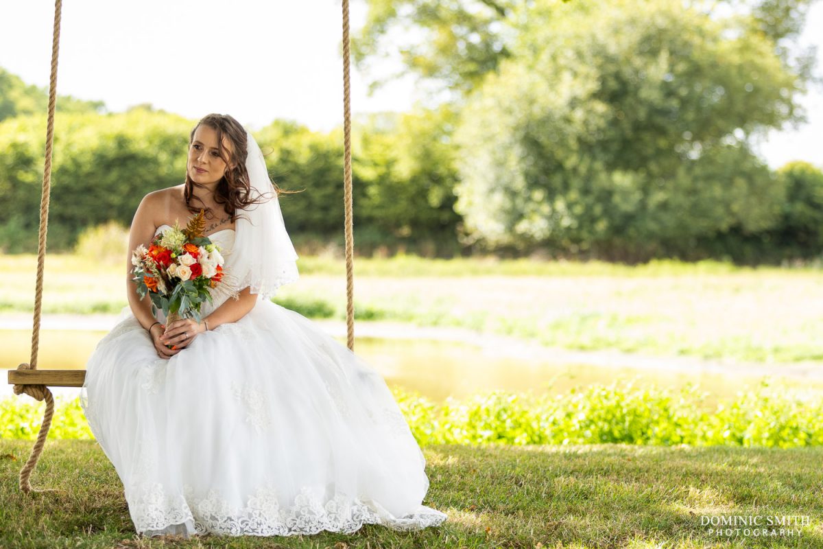Bride sitting on the Southlands Barn swing
