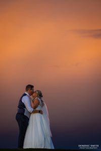 Bride and Groom with a sunlit storm cloud behind them