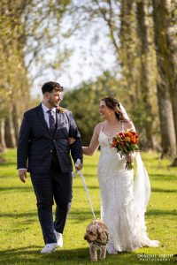 Bride and Groom walking with their dog at Millwards Estate
