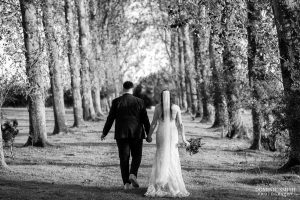 Bride and Groom walk down the avenue at Millwards Estate