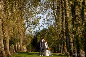 Bride and Groom on the tree lined avenue at Millwards Estate