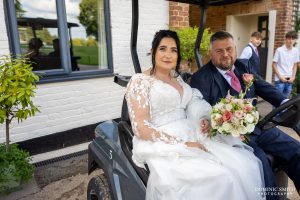 Bride and Groom posing on the Golf Buggies
