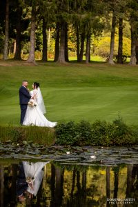 Bride and Groom reflecting in the Cottesmore Golf Club lake