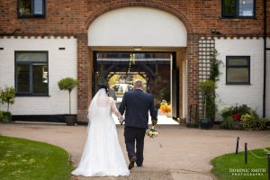 Bride and Groom walking through Cottesmore Golf Club