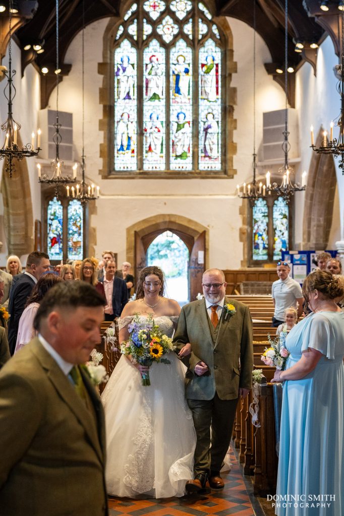 Bride being escorted down the aisle
