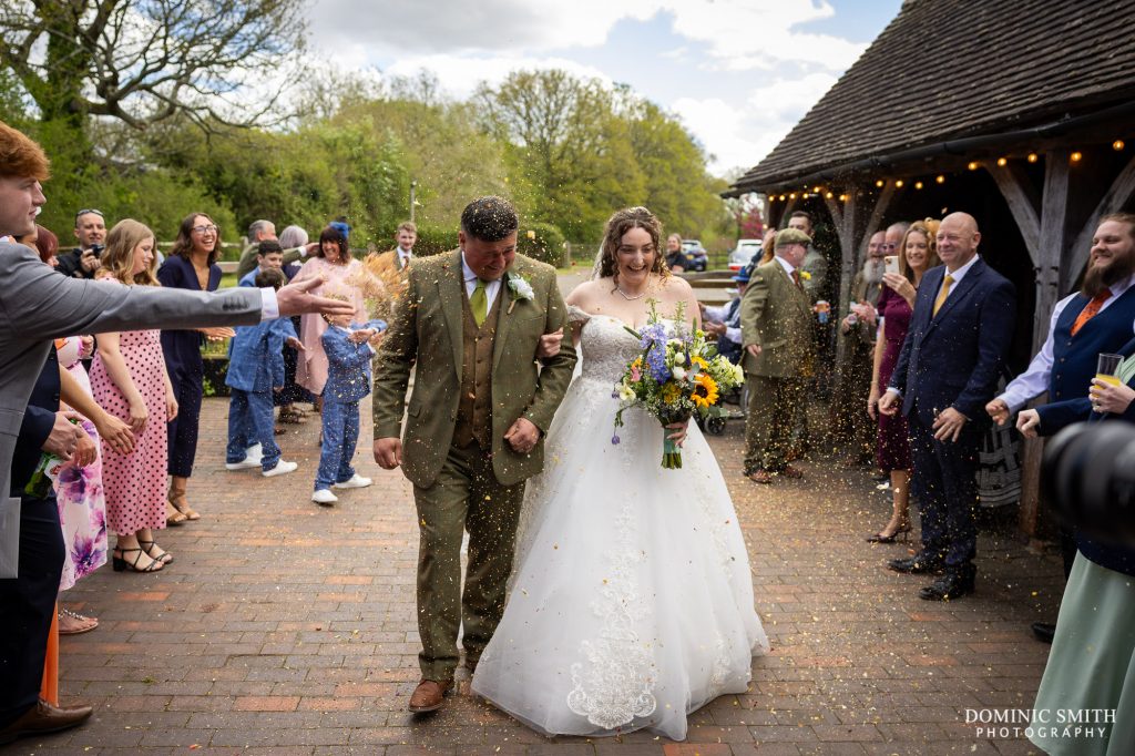 Bride and Groom walking through confetti at Gildings Barns