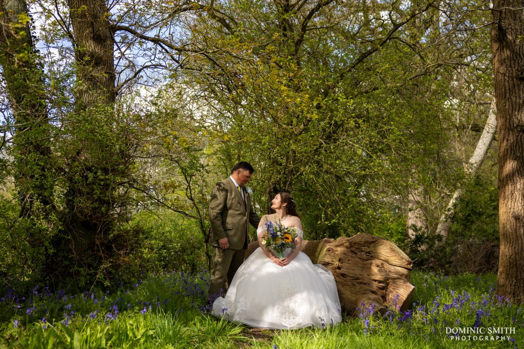 Bride and Groom on the woodland bench at Gildings Barns