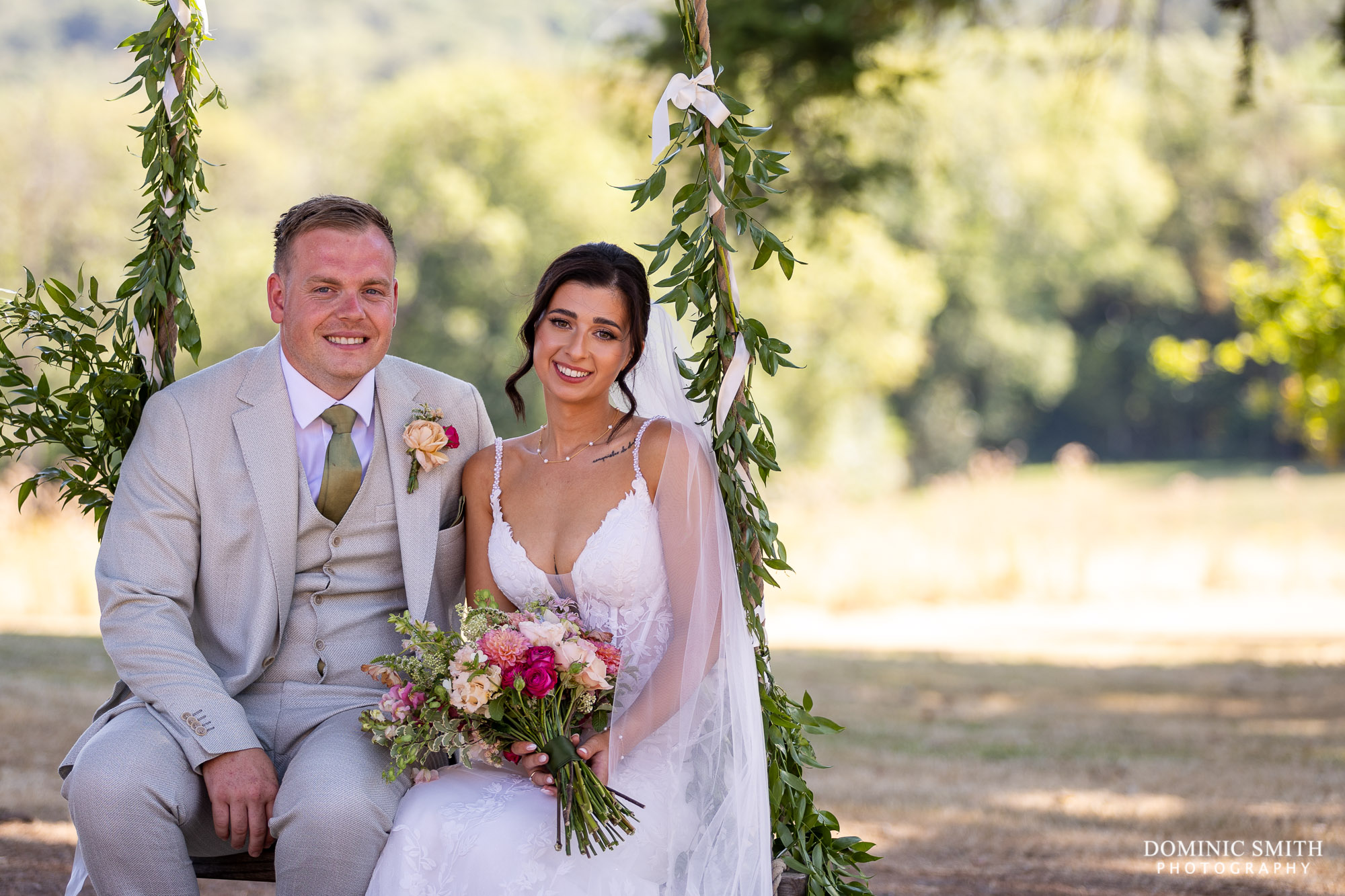 Bride and Groom sitting on swing at Highley Manor
